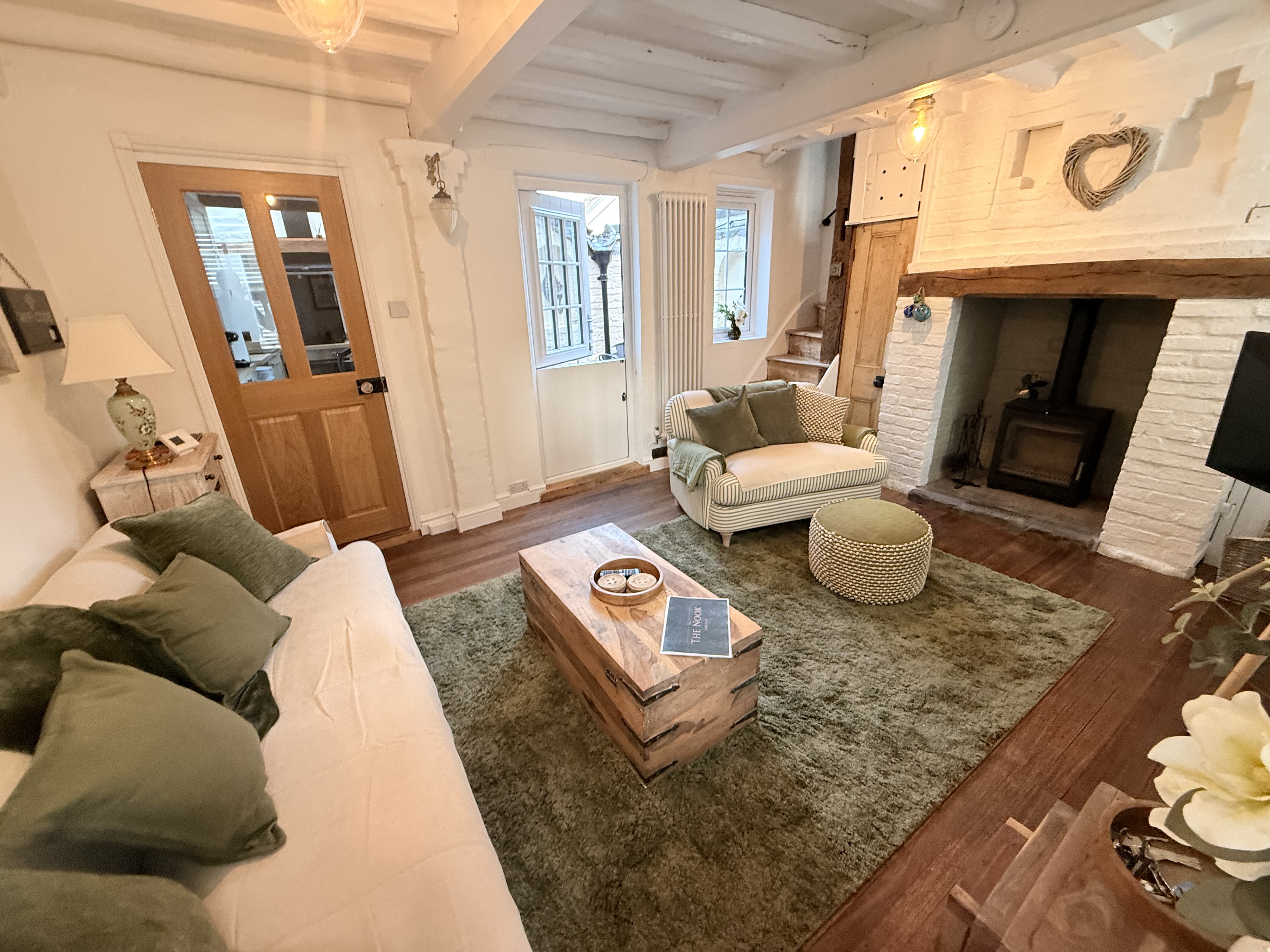 The Nook's sitting room with sofas and a log burner